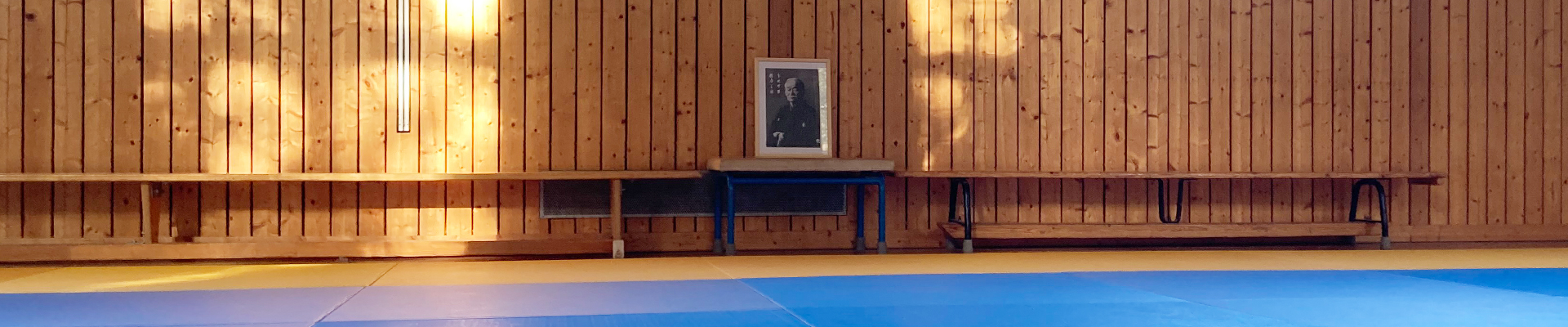 Turnhalle in der Pettenkofer Grundschule in Berlin Friedrichshain, Jigoro Kanos Bild am Kopf der Judomatte